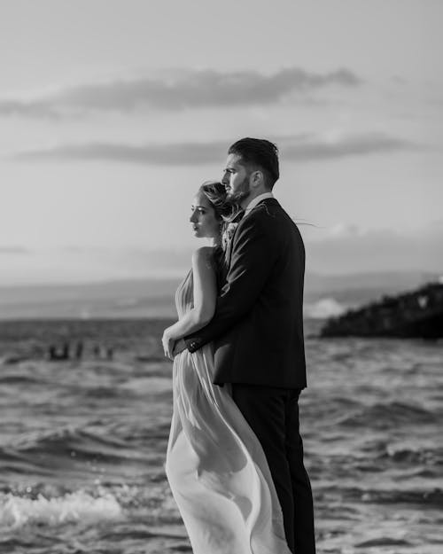 A bride and groom standing in the ocean