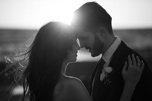 A bride and groom embrace in black and white