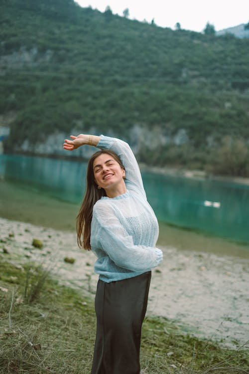 Foto profissional grátis de braço levantado, cabelo castanho, de pé