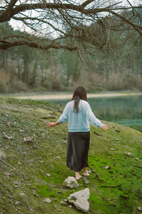 A woman walking on a path near a lake
