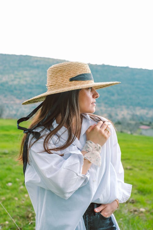 A woman in a straw hat and white shirt