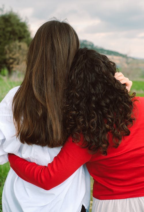 Two women hugging each other in a field