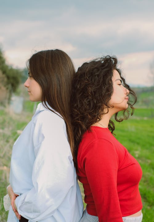 Two Brunettes Standing Back to Back