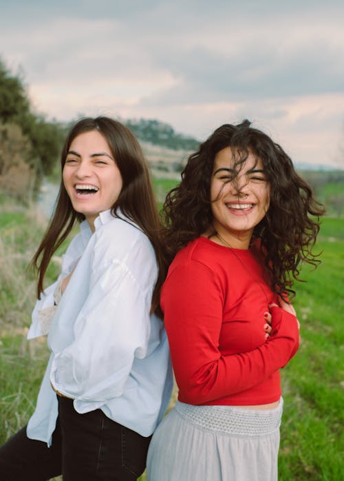 Joyful Women Standing Back to Back