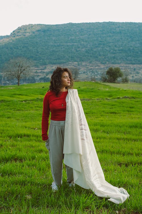 A woman standing in a field with a blanket