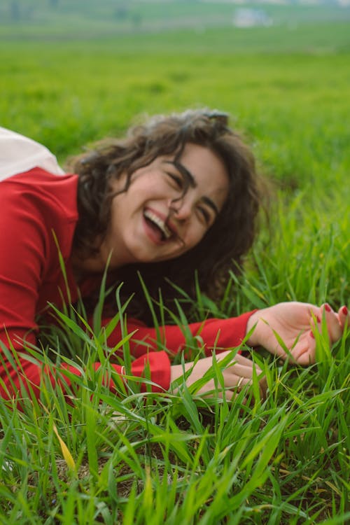 Free Laughing Woman Lying in Grass Stock Photo