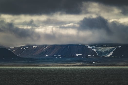 Moody winter landscape with cloudy skies over arctic coast and hills.