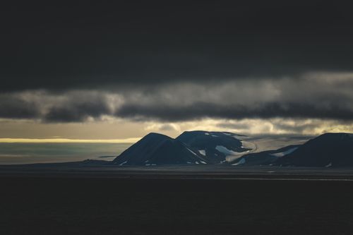 Free Gloomy Arctic mountains under dramatic storm clouds during winter. Stock Photo