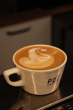 A beautifully crafted cappuccino with swan latte art in a stylish coffee cup, perfect for coffee enthusiasts.