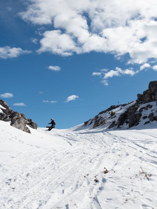 A person riding a snowboard down a snowy mountain