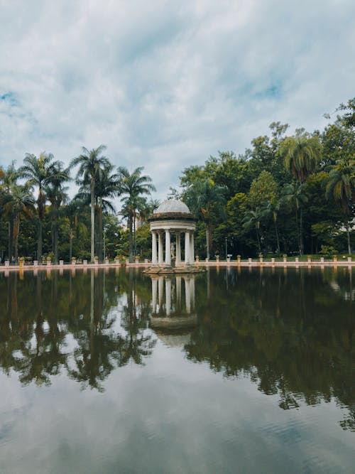 A gazebo in the middle of a lake surrounded by trees