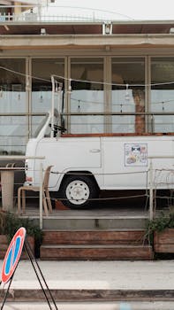 Outdoor seating area with a vintage van at a café in Peschiera del Garda, Italy.