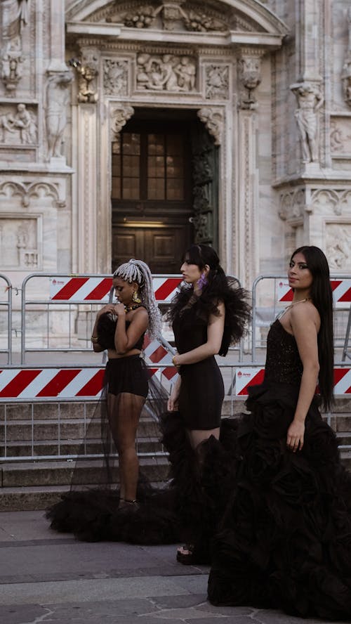 Free Three women in black dresses standing in front of a building Stock Photo