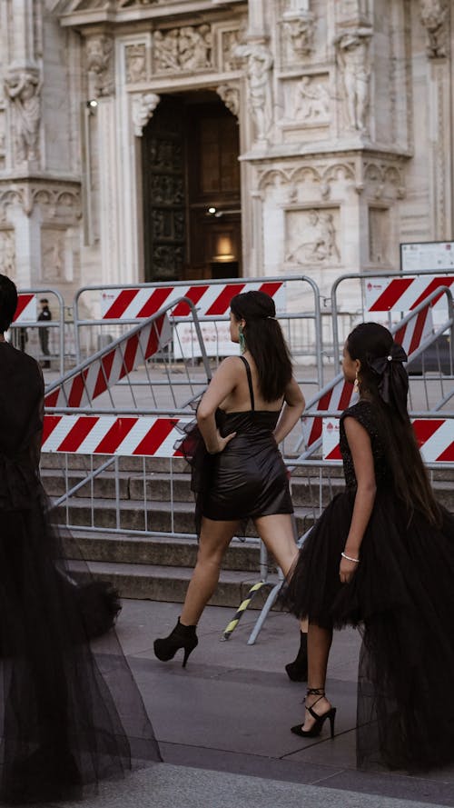 Free A group of women in black dresses walk past a barricade Stock Photo