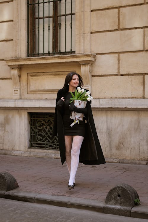 Woman Holding a Bouquet of White Tulips on a Street 