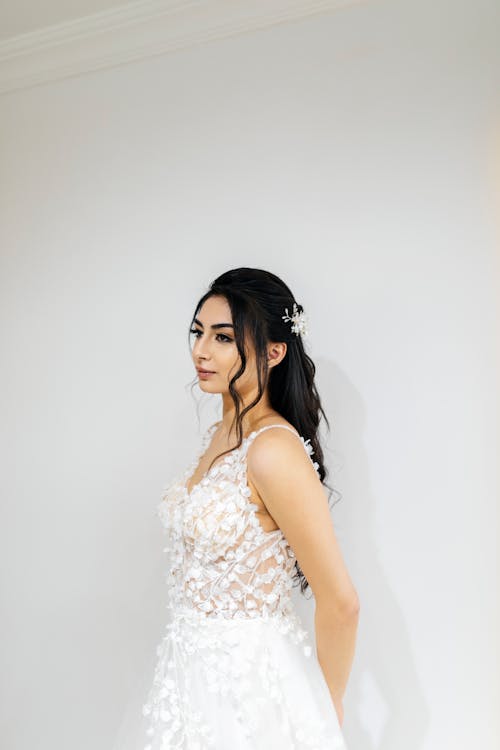 A woman in a wedding dress standing in front of a wall