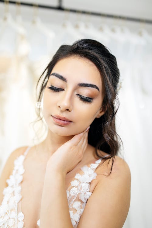 A woman with makeup on her face and wedding dress