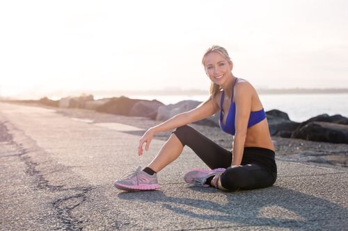 Free Smiling woman exercising on the Gold Coast, Australia, enjoying a sunny workout by the water. Stock Photo