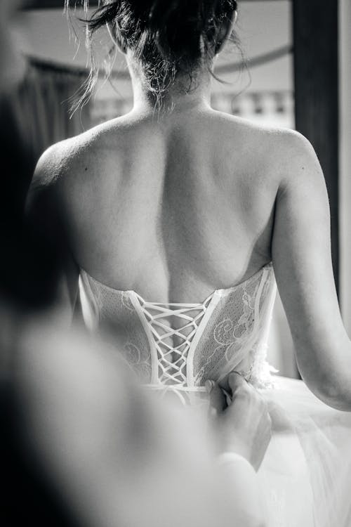 A woman in a wedding dress is looking at herself in the mirror
