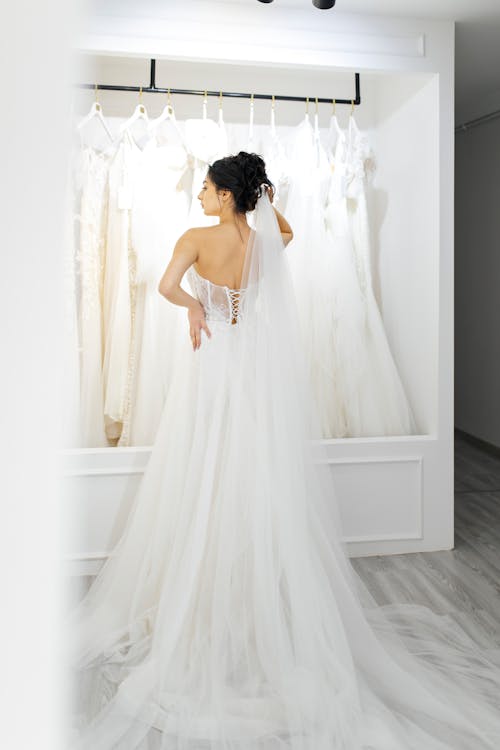 A bride looking at her wedding dress in a store