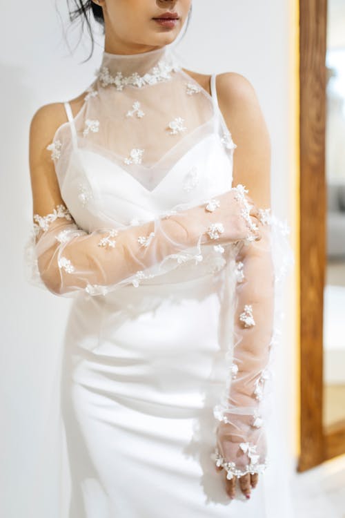 A woman in a wedding dress is posing for a photo