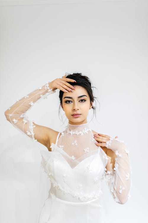 A woman in a wedding dress poses for a photo