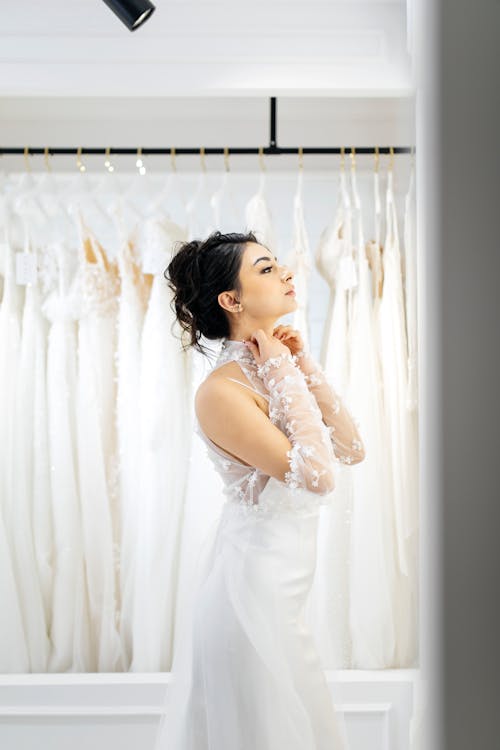 A woman in a wedding dress looking at her wedding gowns