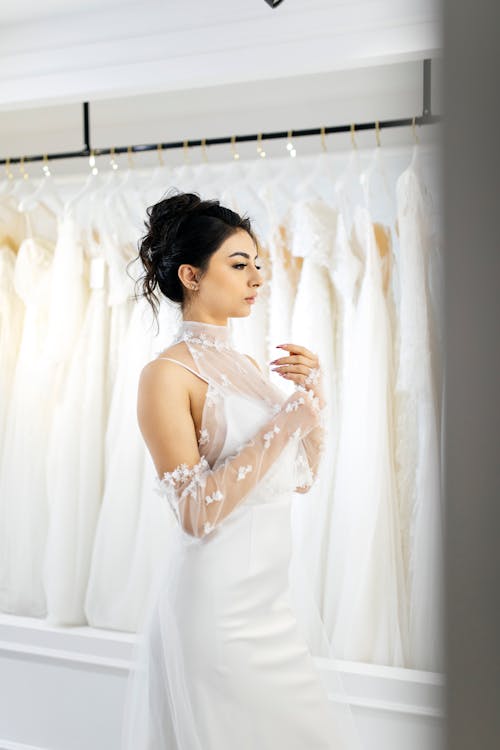 A woman in a wedding dress looking at her wedding gowns