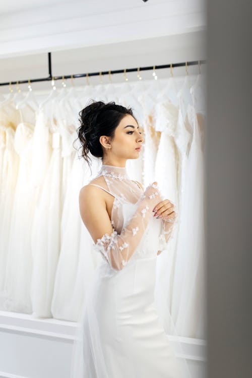 A woman in a wedding dress looking at her wedding gown