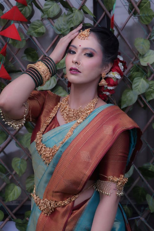 A beautiful woman in a blue and gold sari