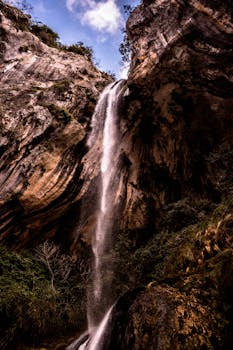 法国荒野的岩石悬崖上，层叠的瀑布令人惊叹，捕捉了自然美景的精髓