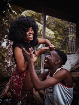 A vibrant scene of a smiling man and woman during an outdoor haircut session in Benin City, Nigeria.