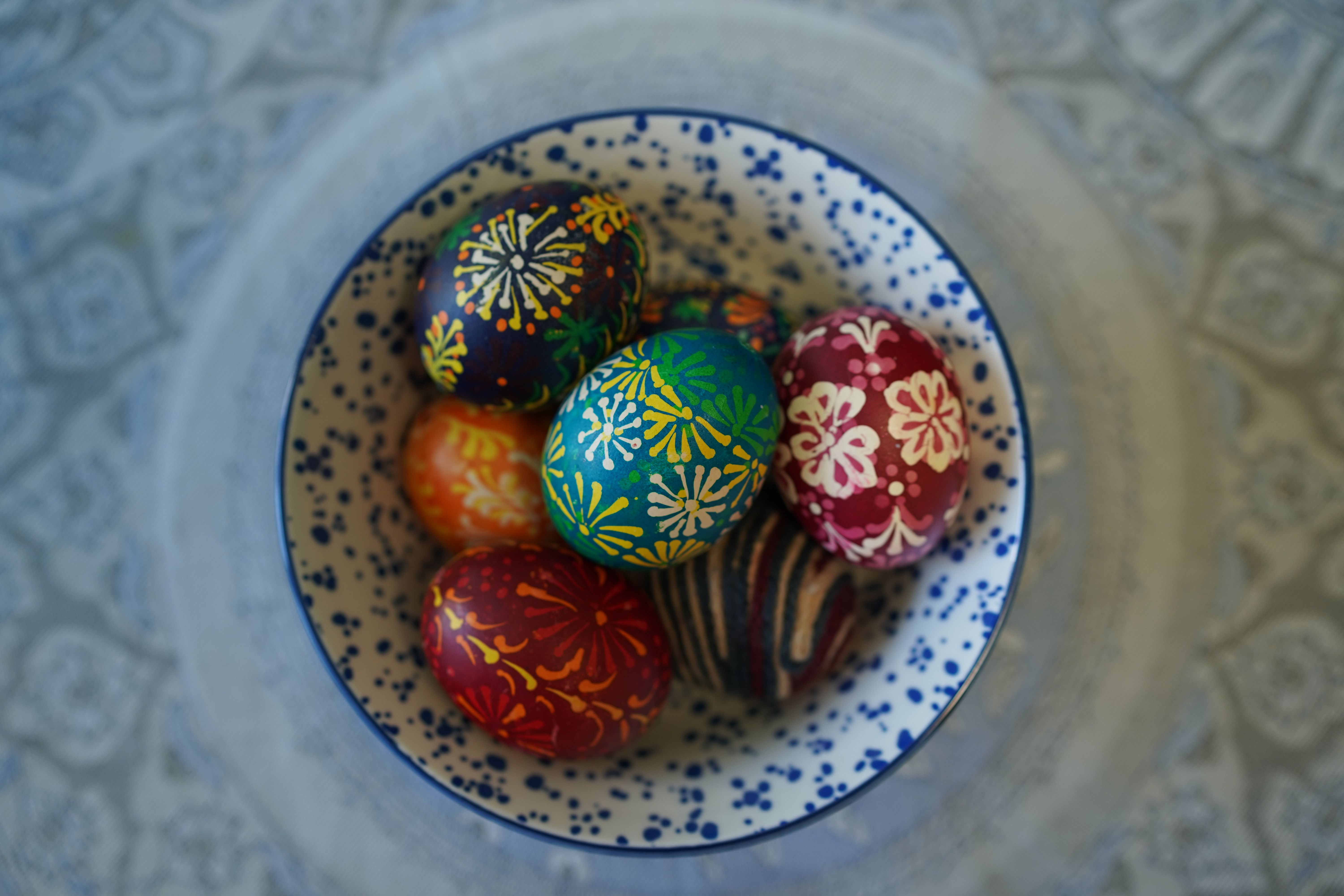 Vibrant collection of intricately painted eggs in a bowl