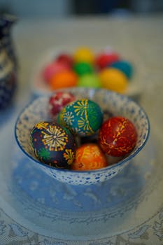 Colorful painted Easter eggs in intricate bowls on a table, highlighting traditional festival themes.