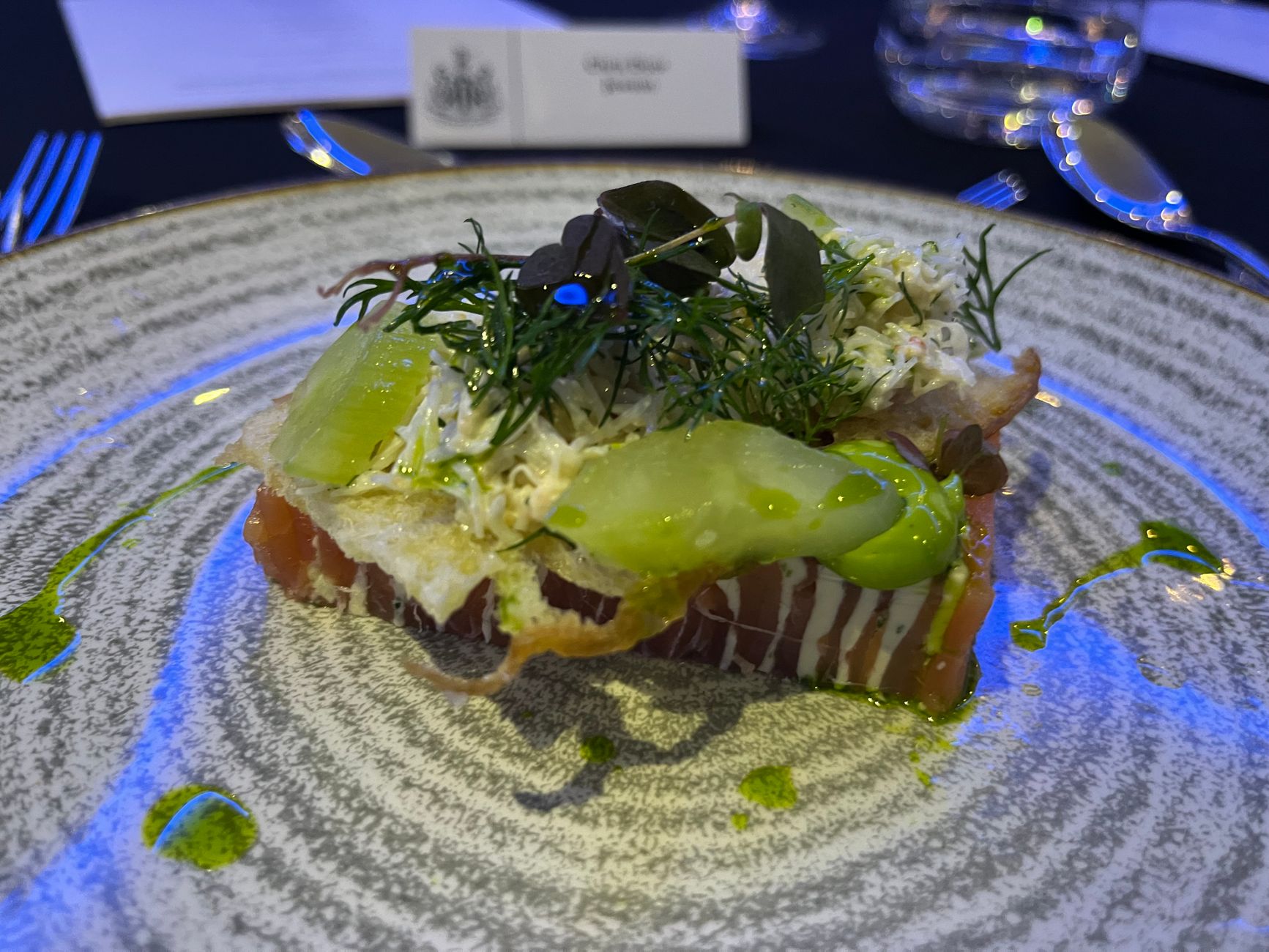 Delicious gourmet salmon dish served with greens and a touch of sauce.