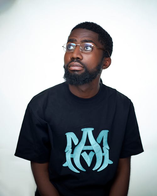 A man with a beard and glasses wearing a black t - shirt