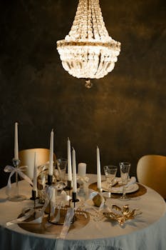 Stylish dining setting with chandelier, candles, and elegant table decor.