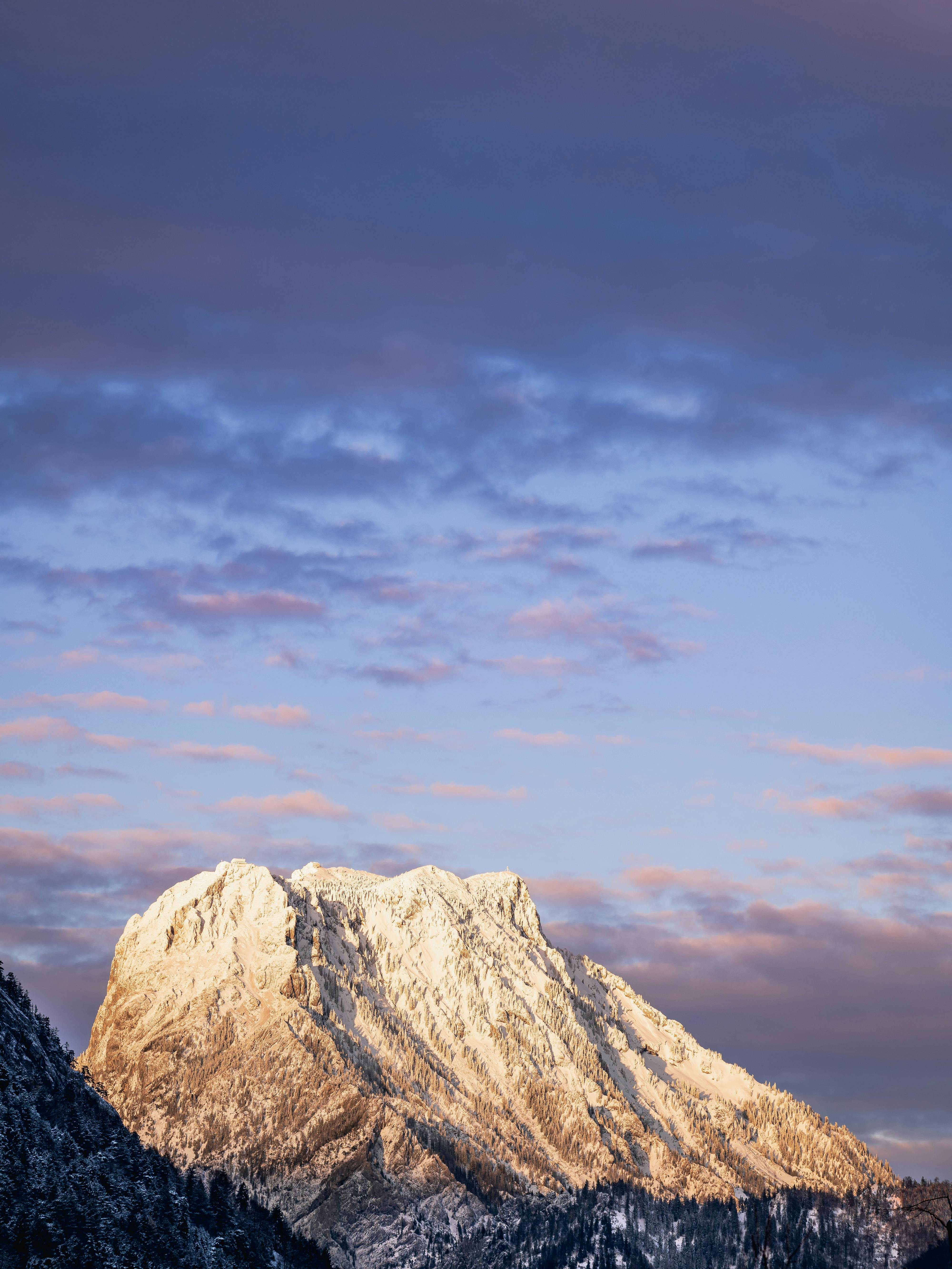 Stunning view of snow-capped mountain peak in Gmunden, Austria at sunset with vibrant sky.
