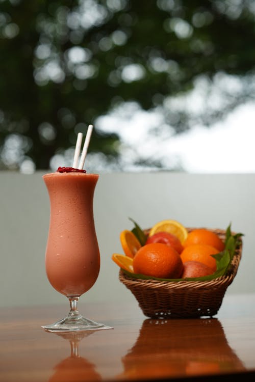 A glass of fruit juice and a basket of fruit