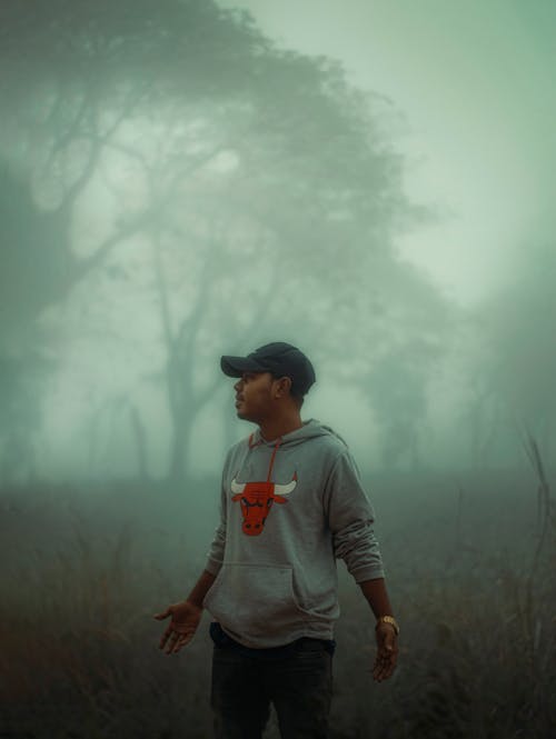 A man standing in the foggy woods