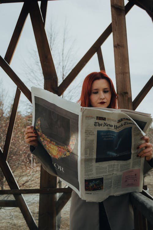 Free Woman Standing and Reading Newspaper Stock Photo