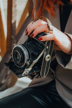 Close-up of hands holding an antique camera, showcasing retro photography.
