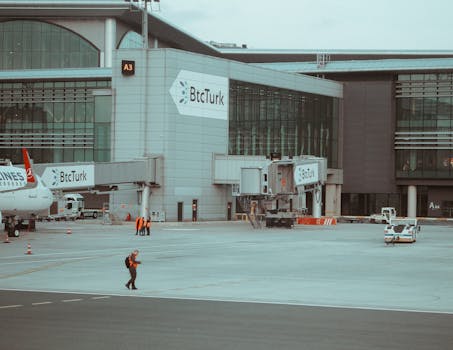 Istanbul airport terminal with BtcTurk branding and ground staff in action.
