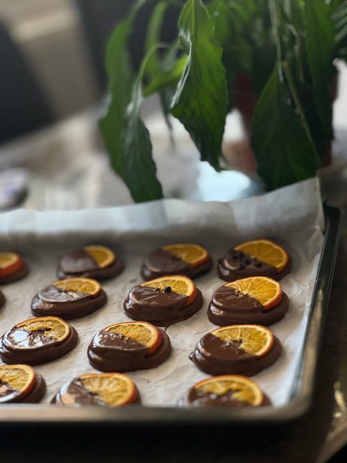 Free Close-up of chocolate-dipped orange slices drying on a baking tray. Stock Photo