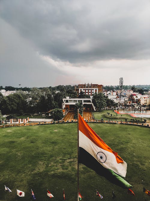 Indian flag flying over a park with a cloudy sky