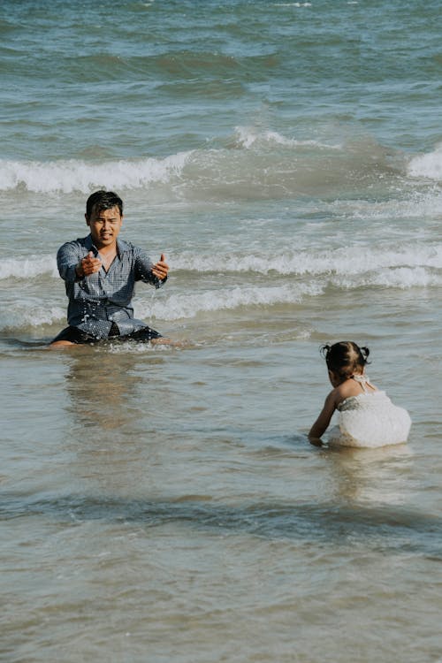 A Man with his Daughter Playing in Sea