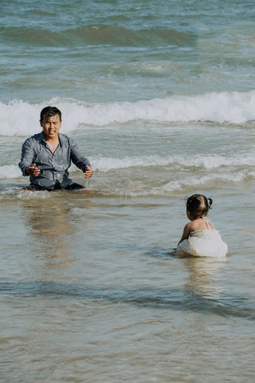 A man and a little girl in the ocean