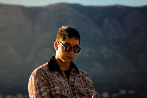 A man in sunglasses standing in front of mountains