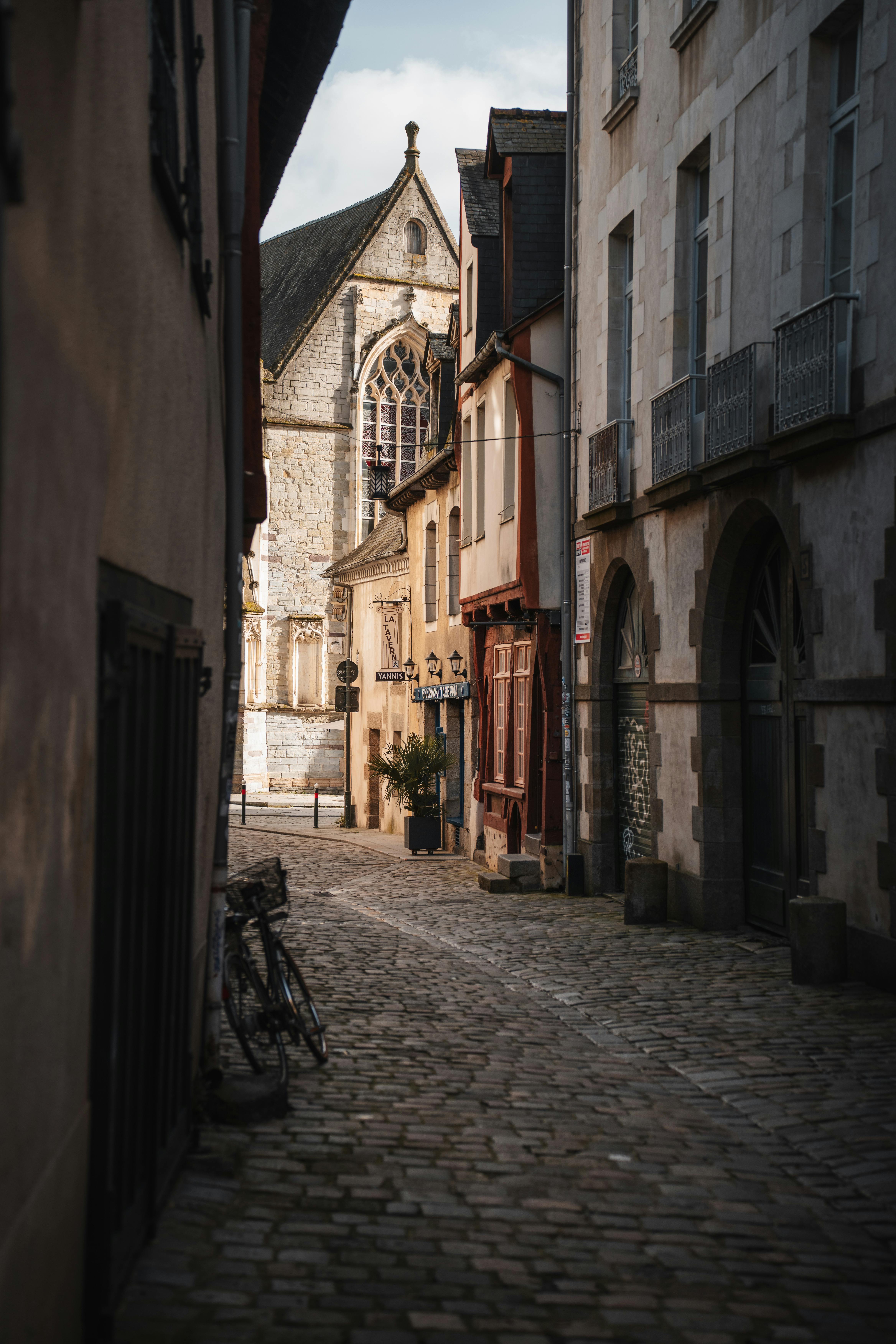 Discover the charm of an empty cobblestone alley in historic Rennes, France with traditional architecture.