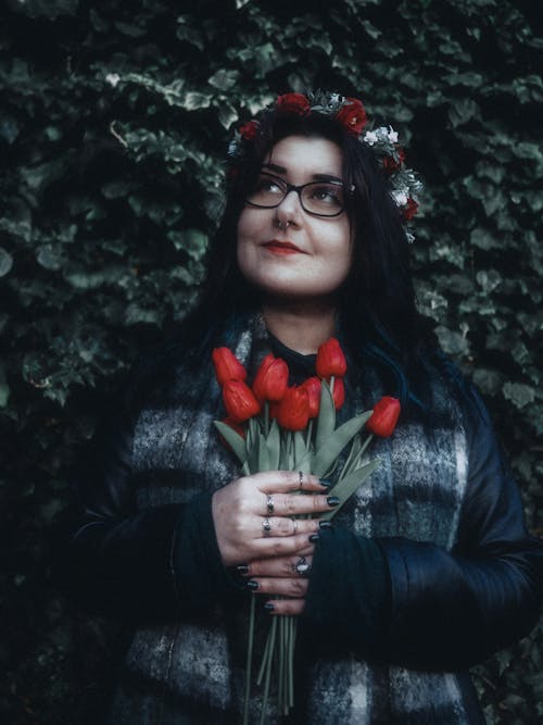 A woman with glasses and flowers in her hands